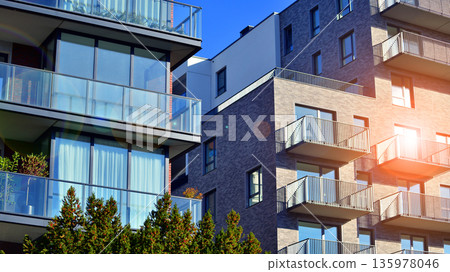 Apartment residential house and home facade architecture and outdoor facilities. Blue sky on the background. Sunlight in sunrise. 135978046