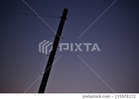 Sunset sky and silhouette of utility poles Sunset sky and silhouette of utility poles 135978172