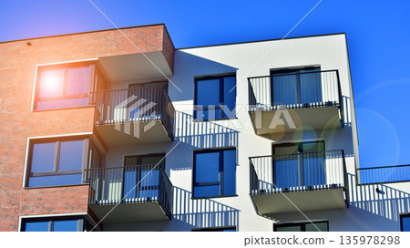 Apartment residential house and home facade architecture and outdoor facilities. Blue sky on the background. Sunlight in sunrise. 135978298
