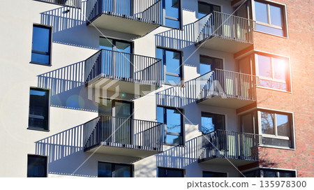 Apartment residential house and home facade architecture and outdoor facilities. Blue sky on the background. Sunlight in sunrise. Apartment residential house and home facade architecture and outdoor facilities. Blue sky on the background. Sunlight in sunrise. 135978300