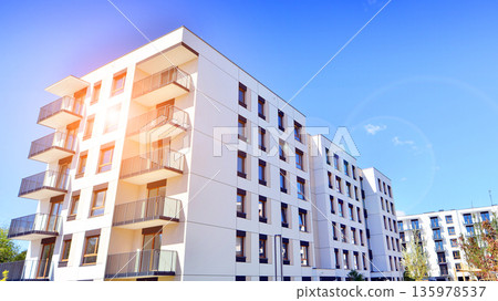 Apartment residential house and home facade architecture and outdoor facilities. Blue sky on the background. Sunlight in sunrise. Apartment residential house and home facade architecture and outdoor facilities. Blue sky on the background. Sunlight in sunrise. 135978537