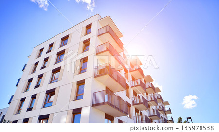 Apartment residential house and home facade architecture and outdoor facilities. Blue sky on the background. Sunlight in sunrise. 135978538