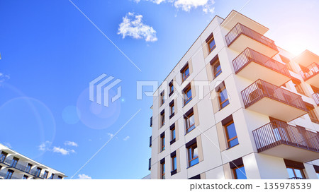 Apartment residential house and home facade architecture and outdoor facilities. Blue sky on the background. Sunlight in sunrise. Apartment residential house and home facade architecture and outdoor facilities. Blue sky on the background. Sunlight in sunrise. 135978539