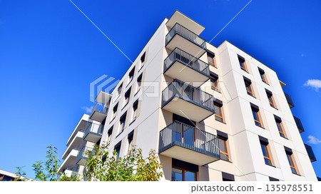Apartment residential house and home facade architecture and outdoor facilities. Blue sky on the background. Sunlight in sunrise. 135978551