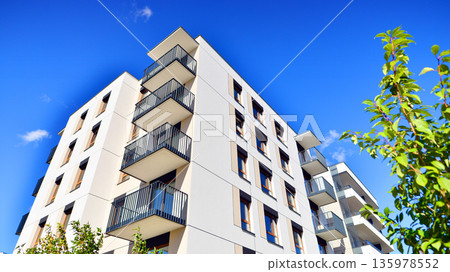 Apartment residential house and home facade architecture and outdoor facilities. Blue sky on the background. Sunlight in sunrise. Apartment residential house and home facade architecture and outdoor facilities. Blue sky on the background. Sunlight in sunrise. 135978552