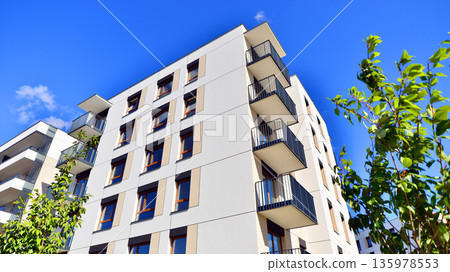 Apartment residential house and home facade architecture and outdoor facilities. Blue sky on the background. Sunlight in sunrise. Apartment residential house and home facade architecture and outdoor facilities. Blue sky on the background. Sunlight in sunrise. 135978553