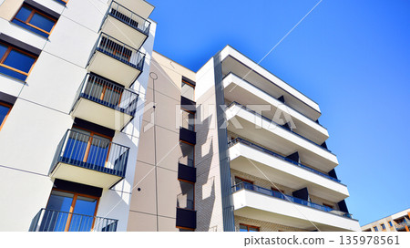 Apartment residential house and home facade architecture and outdoor facilities. Blue sky on the background. Sunlight in sunrise. Apartment residential house and home facade architecture and outdoor facilities. Blue sky on the background. Sunlight in sunrise. 135978561