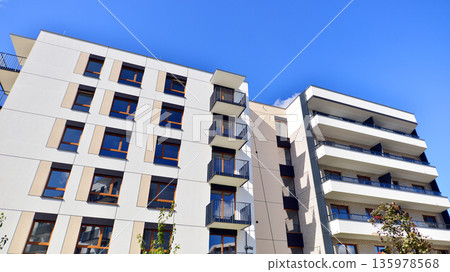 Apartment residential house and home facade architecture and outdoor facilities. Blue sky on the background. Sunlight in sunrise. Apartment residential house and home facade architecture and outdoor facilities. Blue sky on the background. Sunlight in sunrise. 135978568