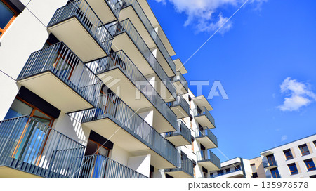Apartment residential house and home facade architecture and outdoor facilities. Blue sky on the background. Sunlight in sunrise. Apartment residential house and home facade architecture and outdoor facilities. Blue sky on the background. Sunlight in sunrise. 135978578