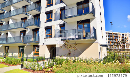 Apartment residential house and home facade architecture and outdoor facilities. Blue sky on the background. Sunlight in sunrise. Apartment residential house and home facade architecture and outdoor facilities. Blue sky on the background. Sunlight in sunrise. 135978579