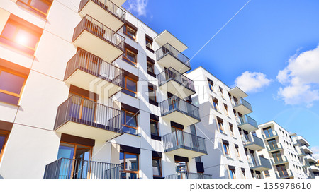 Apartment residential house and home facade architecture and outdoor facilities. Blue sky on the background. Sunlight in sunrise. Apartment residential house and home facade architecture and outdoor facilities. Blue sky on the background. Sunlight in sunrise. 135978610