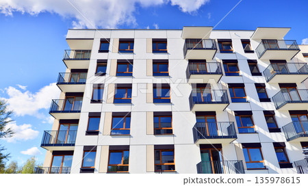 Apartment residential house and home facade architecture and outdoor facilities. Blue sky on the background. Sunlight in sunrise. Apartment residential house and home facade architecture and outdoor facilities. Blue sky on the background. Sunlight in sunrise. 135978615