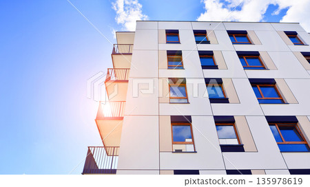Apartment residential house and home facade architecture and outdoor facilities. Blue sky on the background. Sunlight in sunrise. Apartment residential house and home facade architecture and outdoor facilities. Blue sky on the background. Sunlight in sunrise. 135978619