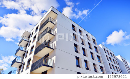 Apartment residential house and home facade architecture and outdoor facilities. Blue sky on the background. Sunlight in sunrise. Apartment residential house and home facade architecture and outdoor facilities. Blue sky on the background. Sunlight in sunrise. 135978621