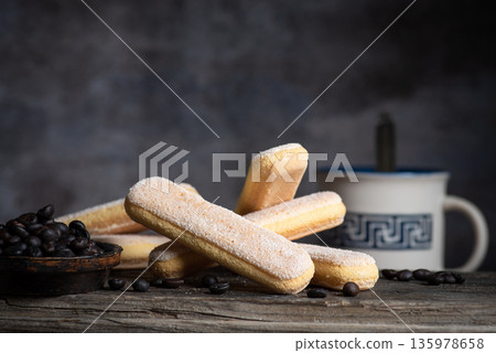 Italian Sponge Fingers Cookies for Tiramisu on Plate Dark Background 135978658