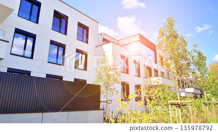 Modern architecture of urban residential apartment buildings on a sunny day. Low-rise apartment buildings with large windows and extensive terraces. White facade of a modern apartment building. Modern architecture of urban residential apartment buildings on a sunny day. Low-rise apartment buildings with large windows and extensive terraces. White facade of a modern apartment building. 135978792