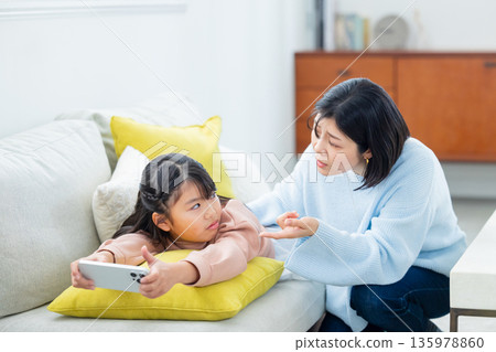 玩智慧型手機的小學生女孩 135978860