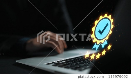 Professional hand using laptop with digital award badge symbolizing success, quality, and achievement in online work or business environment Gluon 135979092