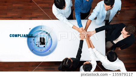 Team Collaboration on Compliance Strategy with Digital Interface and Diverse Professionals Engaging in a Collective Effort for Success Trope Team Collaboration on Compliance Strategy with Digital Interface and Diverse Professionals Engaging in a Collective Effort for Success Trope 135979117