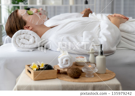 Couple customer indulges in rejuvenating with cucumber facial care. Quiescent Couple customer indulges in rejuvenating with cucumber facial care. Quiescent 135979242
