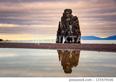Hvitserkur Rock stands majestically in Iceland, surrounded by tranquil waters. The scene captures the interplay of light and clouds at sunset, showcasing Iceland's stunning natural beauty. Hvitserkur Rock stands majestically in Iceland, surrounded by tranquil waters. The scene captures the interplay of light and clouds at sunset, showcasing Iceland's stunning natural beauty. 135979506
