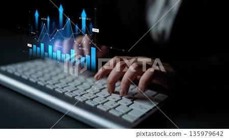 Professional hand typing on keyboard with data analytics graph overlay representing business growth, statistical trends, and digital technology concepts. Scalp Professional hand typing on keyboard with data analytics graph overlay representing business growth, statistical trends, and digital technology concepts. Scalp 135979642