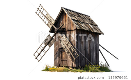 An old wooden windmill is abandoned on a grassy hill in the countryside against a white background. 135979661