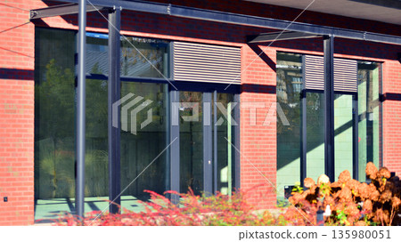 Panoramic windows of new commercial premises. Commercial property in development standard for rent. Modern housing estate. Panoramic windows of new commercial premises. Commercial property in development standard for rent. Modern housing estate. 135980051