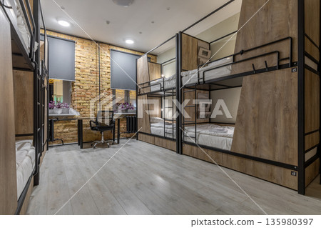 Spacious loft hostel dormitory with bunk beds at night Spacious loft hostel dormitory with bunk beds at night 135980397