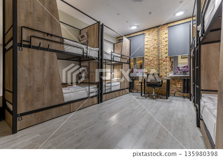 Modern loft hostel dormitory interior with bunk beds at night Modern loft hostel dormitory interior with bunk beds at night 135980398