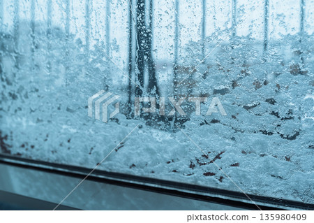 snow pattern on window glass snow pattern on window glass 135980409
