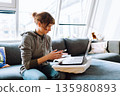 e-shopping while sitting on couch 135980893