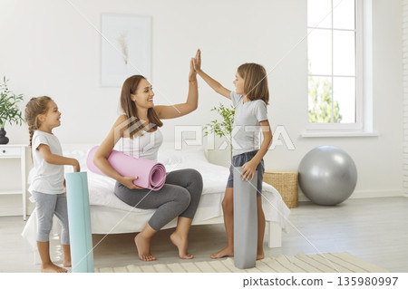 Young mother giving high five with children after morning workout at home Young mother giving high five with children after morning workout at home 135980997