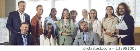 Banner with a group portrait of happy multiethnic people at a work meeting in the office 135981003