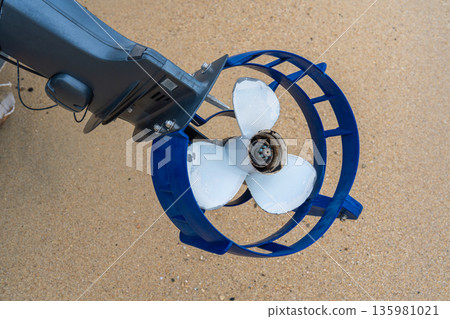 jet engine on the beach. Boat motor propeller on sandy shore ready for use in marine activities near water at daytime jet engine on the beach. Boat motor propeller on sandy shore ready for use in marine activities near water at daytime 135981021