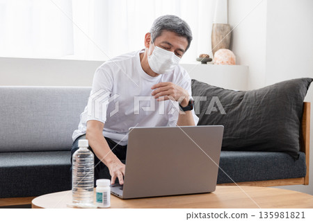 一名因健康狀況不佳而遠距辦公的男子 一名因健康狀況不佳而遠距辦公的男子 135981821