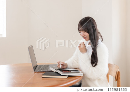 一位女性正在網路上學習 一位女性正在網路上學習 135981863