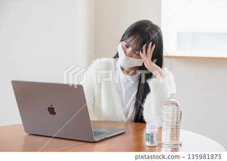 一位身體不適的女性在家操作電腦 一位身體不適的女性在家操作電腦 135981875