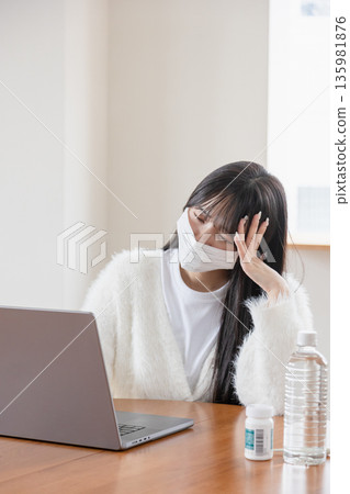 一位身體不適的女性在家操作電腦 135981876