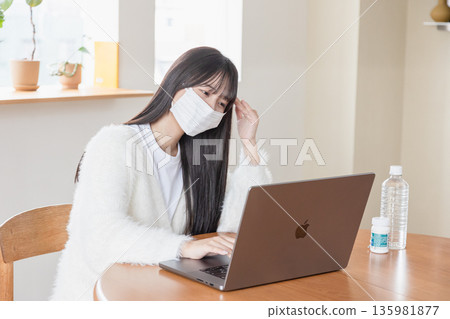 一位身體不適的女性在家操作電腦 135981877