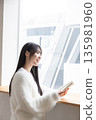 Woman reading by the window 135981960