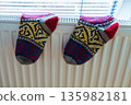 Woolen socks dry on radiator on cold winter day. 135982181