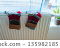Woolen socks dry on radiator on cold winter day. 135982185