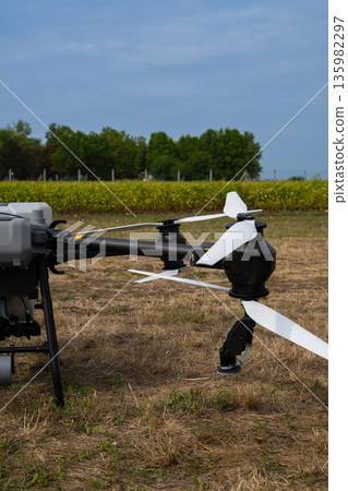 Close-up drone with propellers ready to survey an agricultural field in a rural landscape 135982297