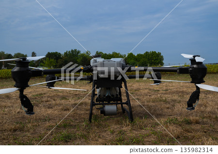 A high-tech agricultural drone sits on a dry field ready for field inspection and data collection 135982314