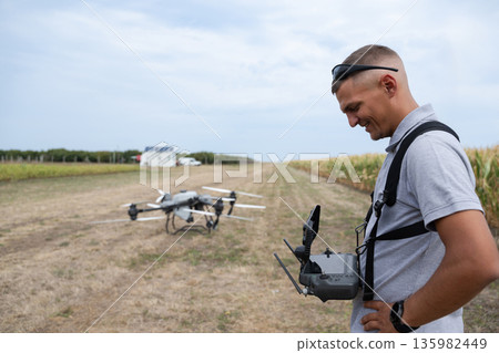 Man with Drone Controller in Field Prepare Flight for Agricultural Aerial Survey Man with Drone Controller in Field Prepare Flight for Agricultural Aerial Survey 135982449