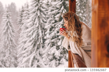 Woman Enjoying Hot Drink in Winter Landscape 135982887