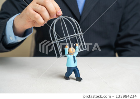 A businessman is trying to cage an office worker to retain valuable employees. Talent retention pressure, toxic control metaphor and ethical boundaries. Workforce freedom, motivation loss A businessman is trying to cage an office worker to retain valuable employees. Talent retention pressure, toxic control metaphor and ethical boundaries. Workforce freedom, motivation loss 135984234