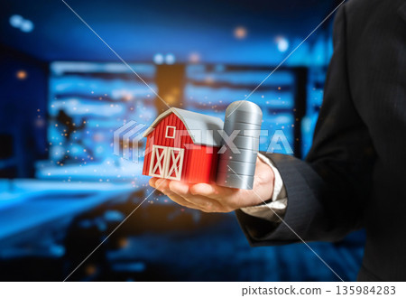 A businessman holding a farm. Agribusiness. Agricultural industry. Investments in farming and innovation. Rural economy growth, food security strategy A businessman holding a farm. Agribusiness. Agricultural industry. Investments in farming and innovation. Rural economy growth, food security strategy 135984283