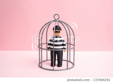 A criminal trapped in a cage. Fighting crime. Serving time, rehabilitation, and isolation from society. Justice system symbol, punishment balance and public safety protection A criminal trapped in a cage. Fighting crime. Serving time, rehabilitation, and isolation from society. Justice system symbol, punishment balance and public safety protection 135984292